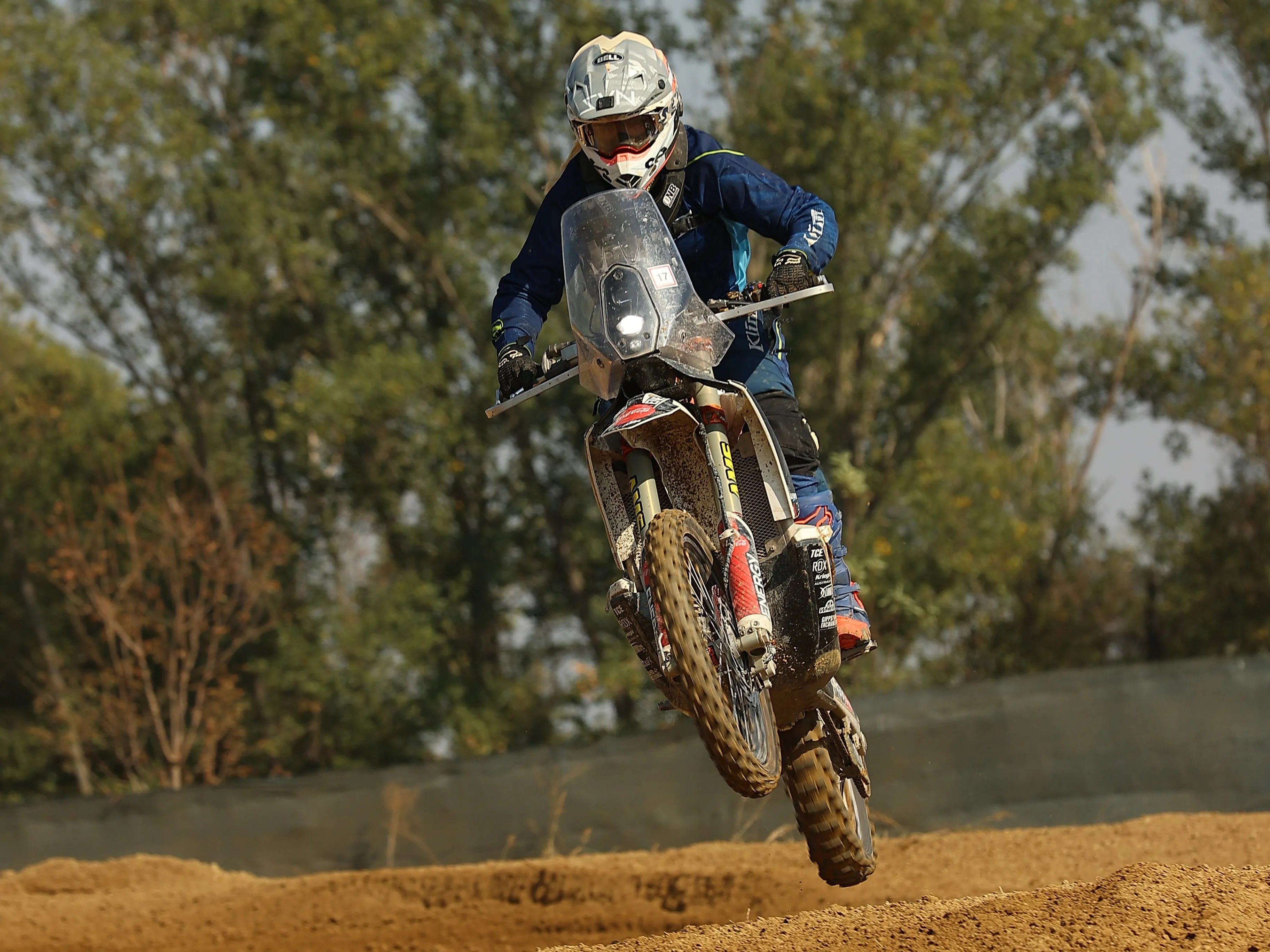 Fahrerin auf der Motocrossstrecke, Vorderrad über der Kante