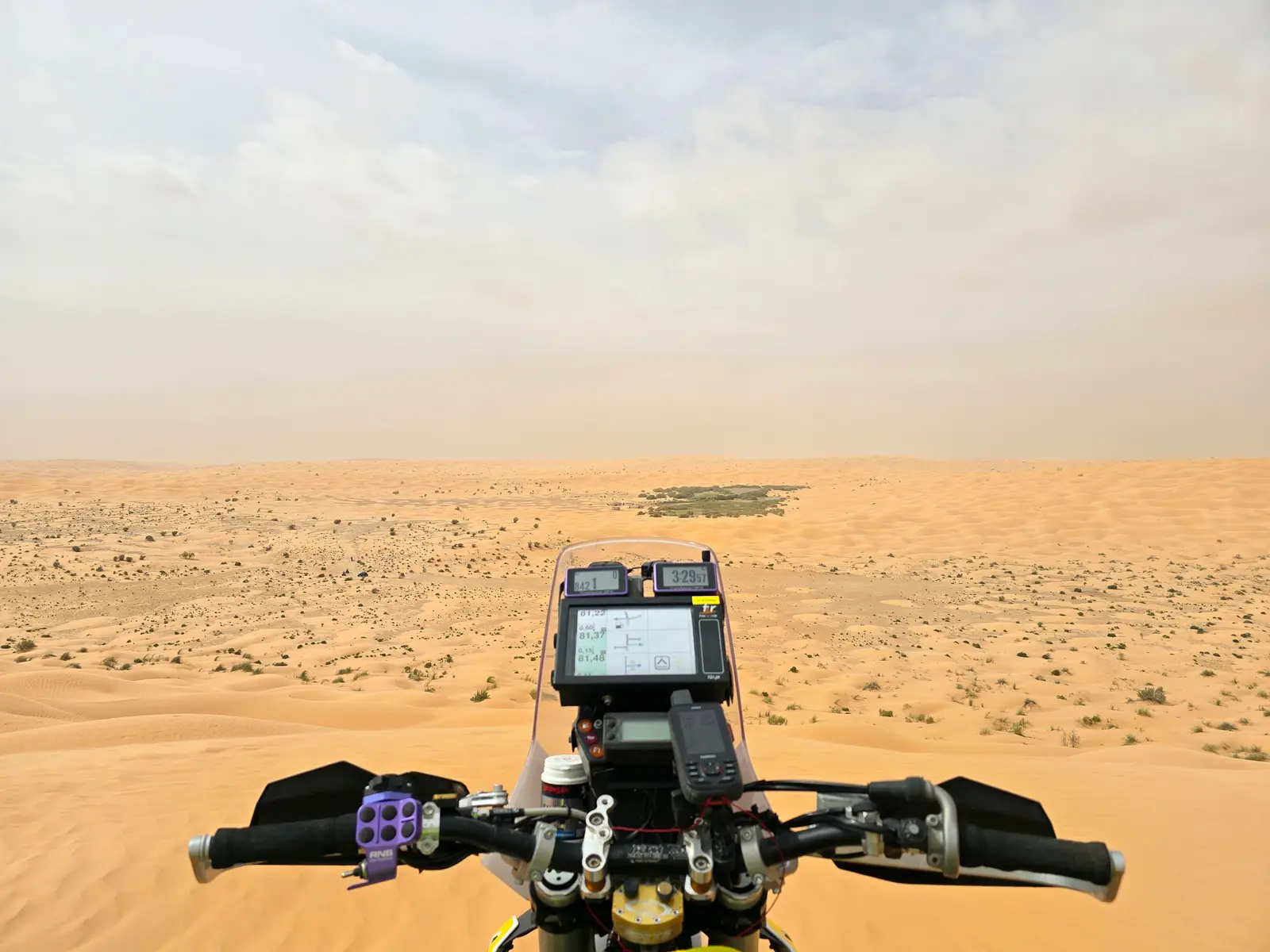 Blick über den Lenker auf das Navigationsgerät und die offene Wüste