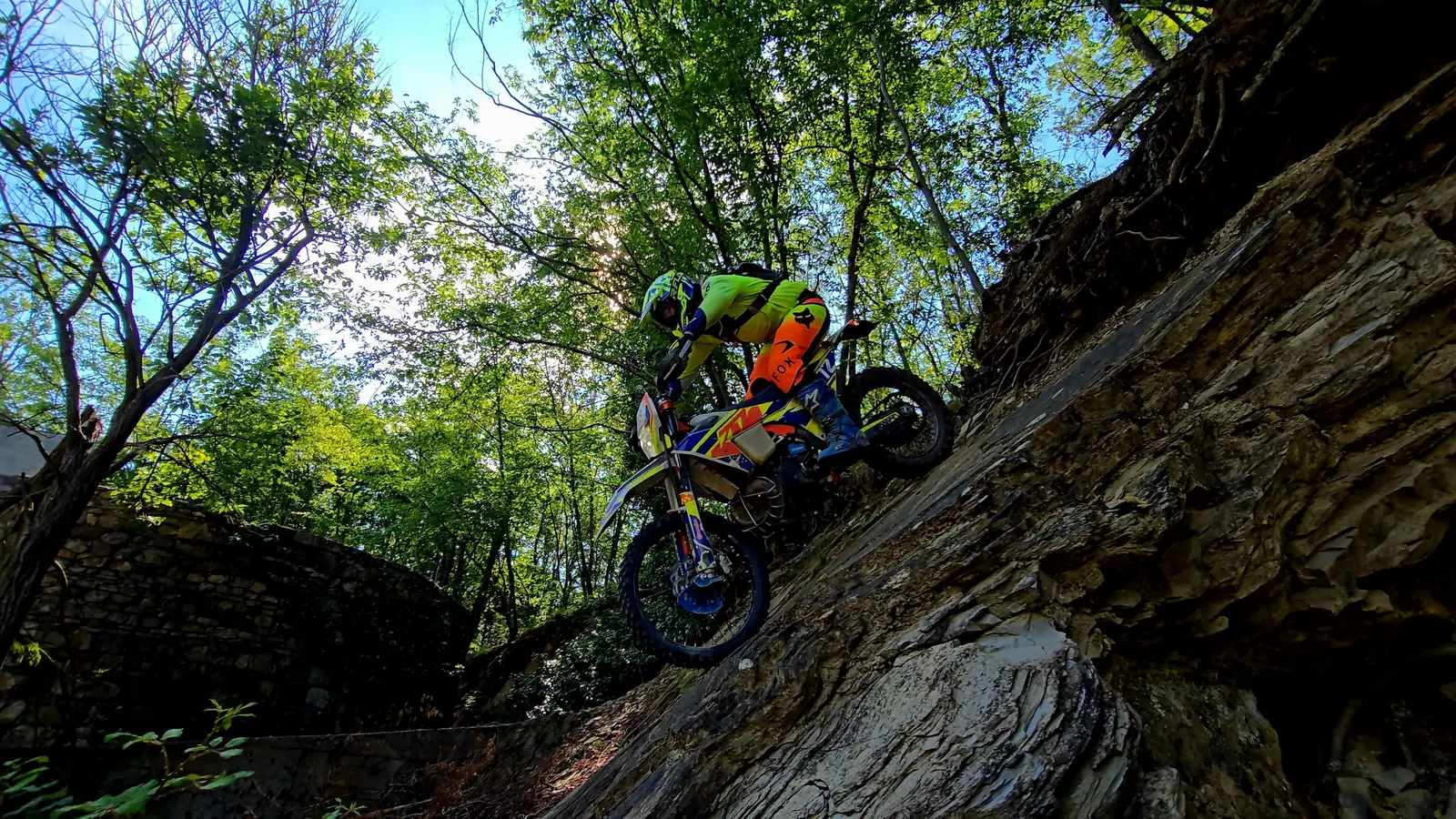 Abfahrt über eine steile Felsplatte im Wald