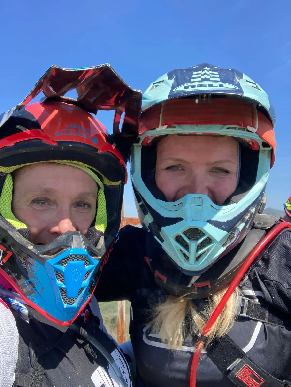 Zwei Fahrerinnen in Enduroausrüstung nebeneinander, Helme auf, Brillen hochgeschoben